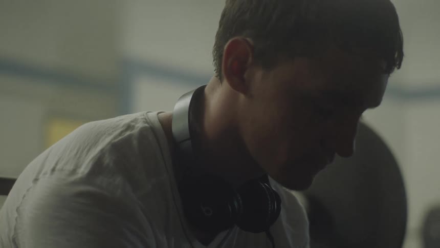 Man wearing headphones around his neck nods his head