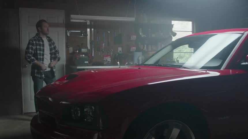 A man opens the door and enters the garage and turns on the light