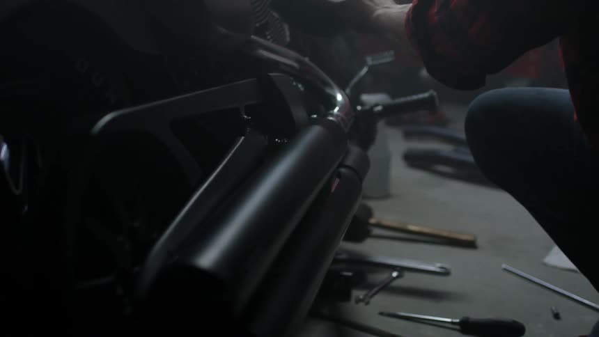 A mechanic puts a part on a motorcycle