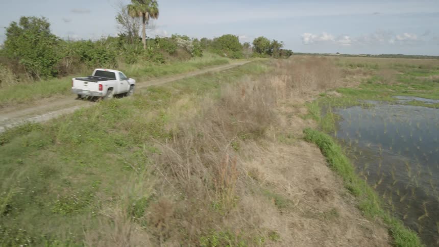 A truck drives on a rural dirt road