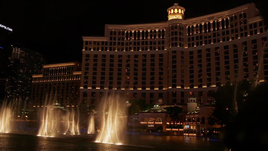 Fountains spray water in unison outside of large casino and hotel buildings