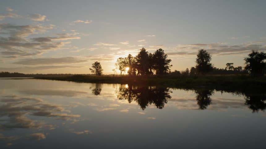 The sun is raising over a calm lake