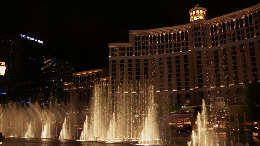 Fountains spray up in front of a large hotel building
