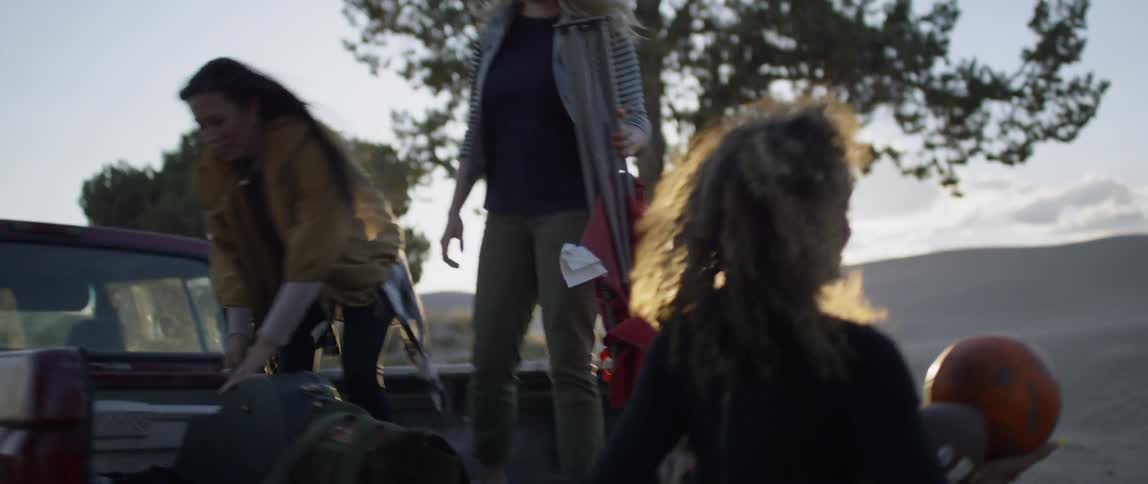 A group of women are unpacking things from the back of a pickup truck