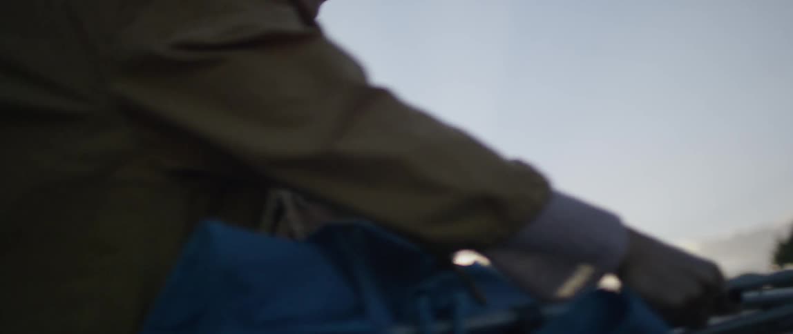 Man and woman assembling their tent near a cloudy sunset