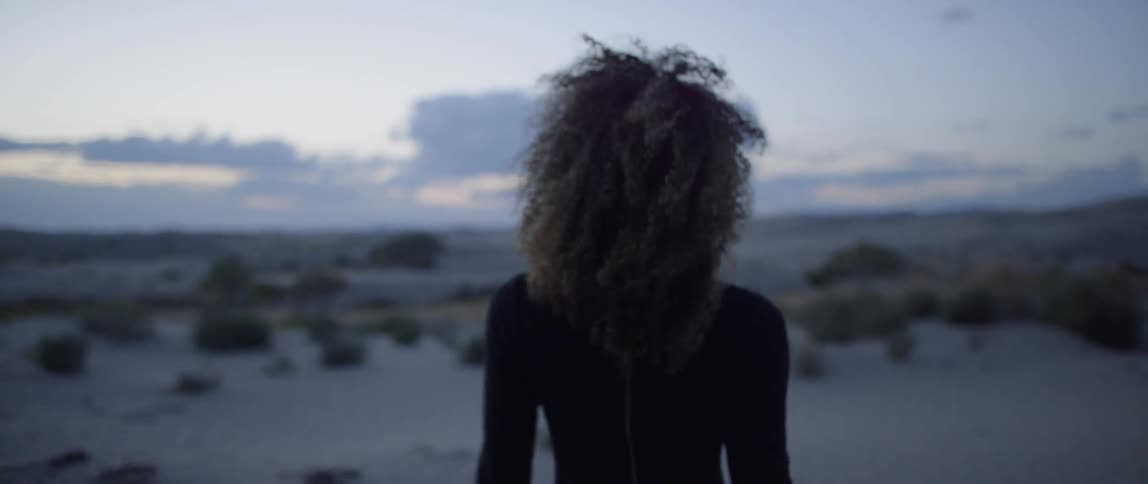 Woman walks outside in the desert at sunset