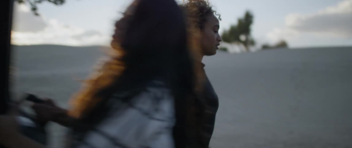 Women load things into the back of a pickup at sunset