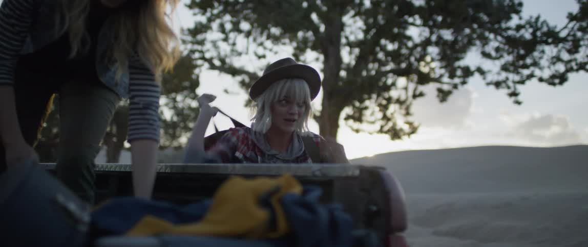 A group of women unload camping equipment from the back of a truck
