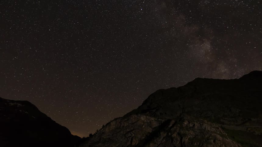 Time-lapse of stars and milky way moving over mountains