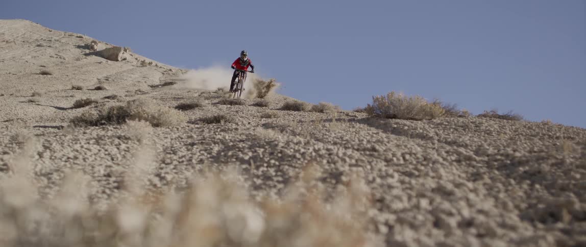 A person turns back and forth while riding his bike downhill