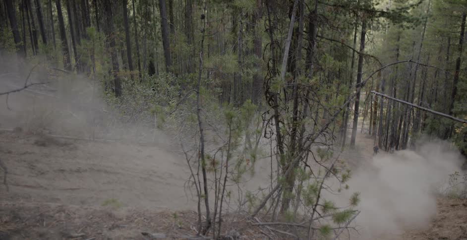Cyclist riding down a steep trail in the woods