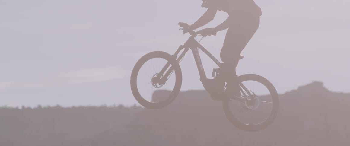 A man flips his front wheel around while doing a jump on his bike
