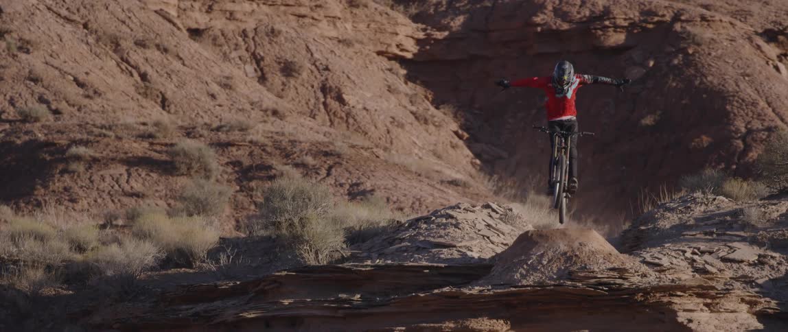 A person riding a bike off of a cliff
