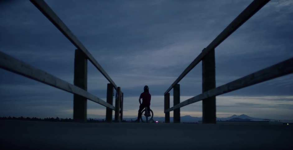 A person sits on their bicycle in the distance