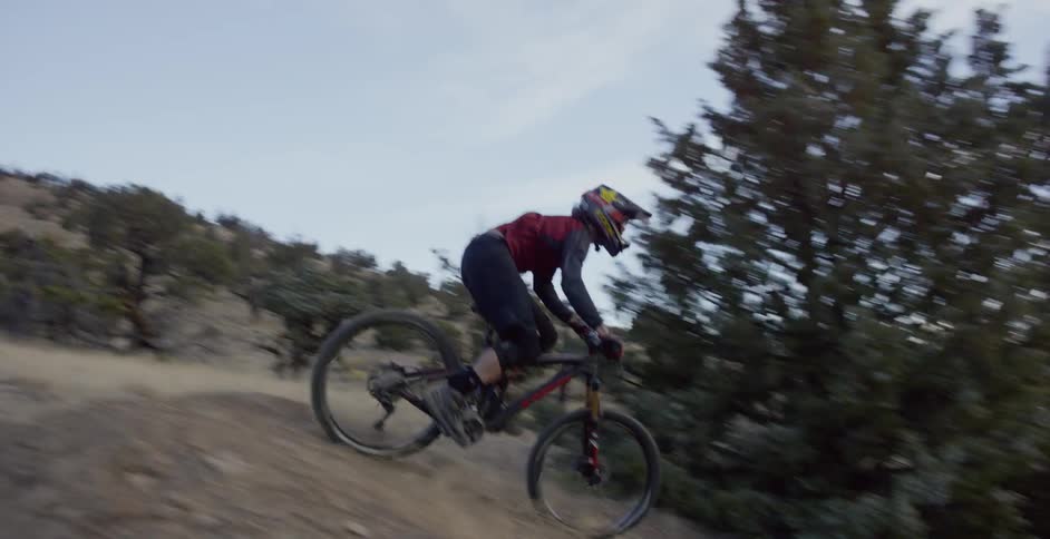 A bicyclist goes over dirt jumps