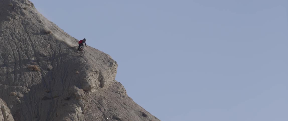 A rider crashes while riding down a steep slope on a mountain bike
