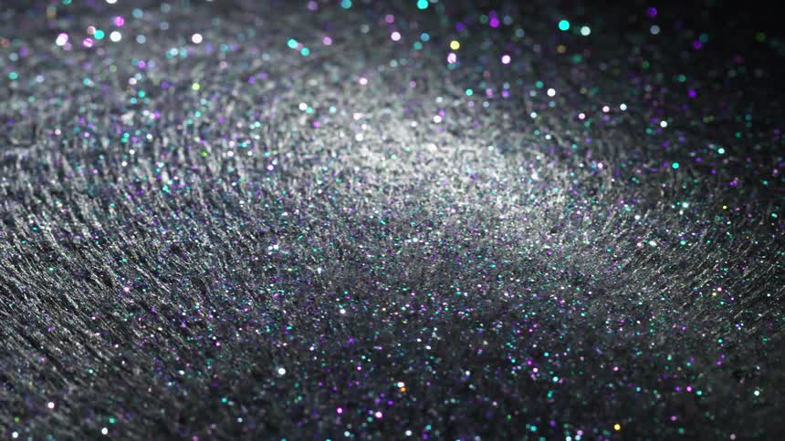 Magnetic fiber and glitter is moving around in a transparent liquid