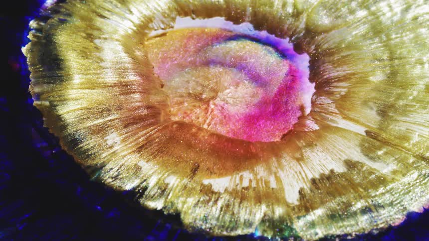 Colors and patterns are moving out from the center of a liquid body