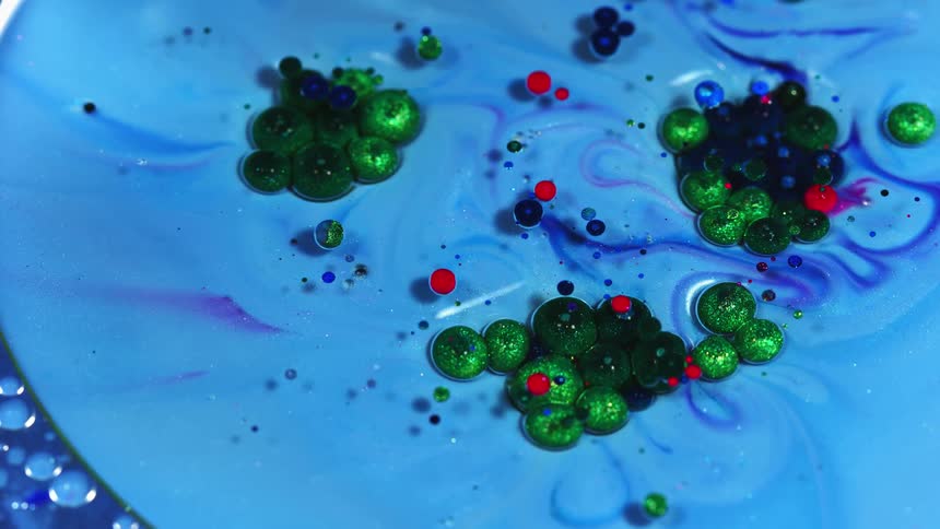 Multi colored liquid formations rotate and attract to each other
