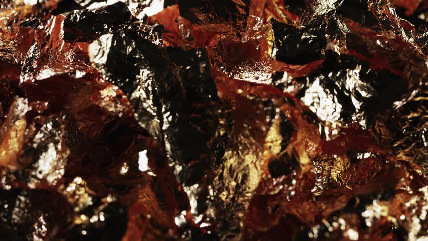 Close up of copper flakes slowly rotating and reflecting light