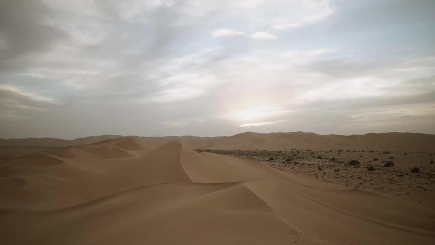 Clouds are drifting over sand dunes during the day