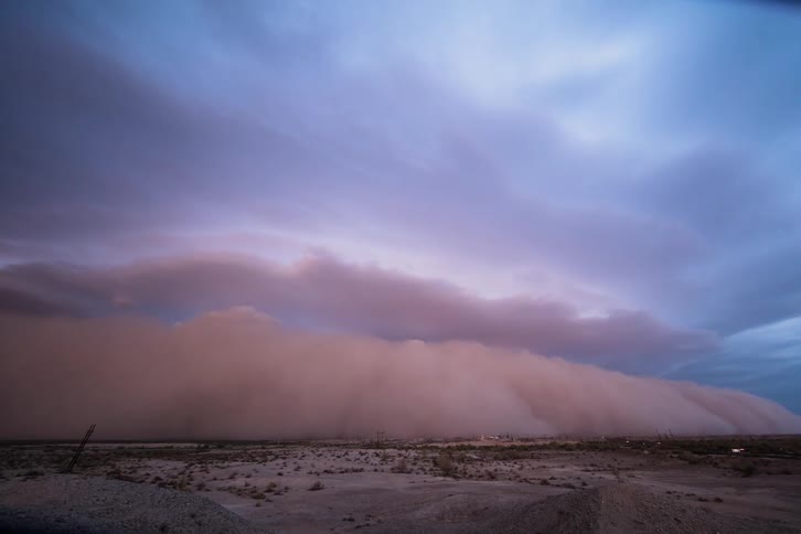 A dust storm approaches and engulfs the plains