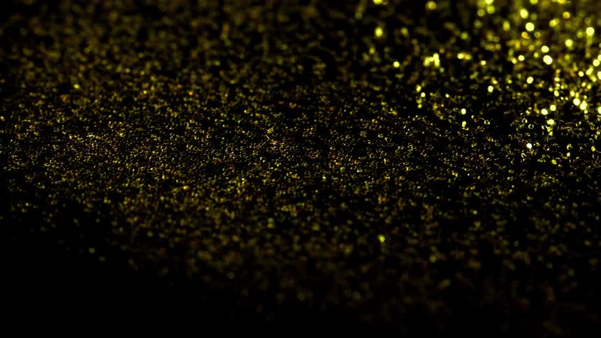 Gold and yellow granules are sprayed and vibrate