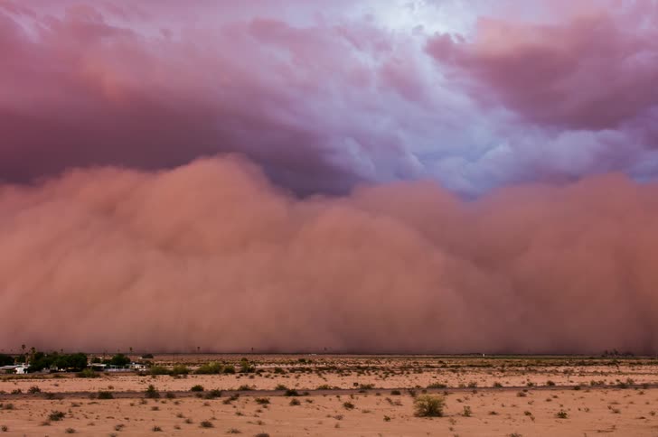 A dust storm approaches and engulfs the plains