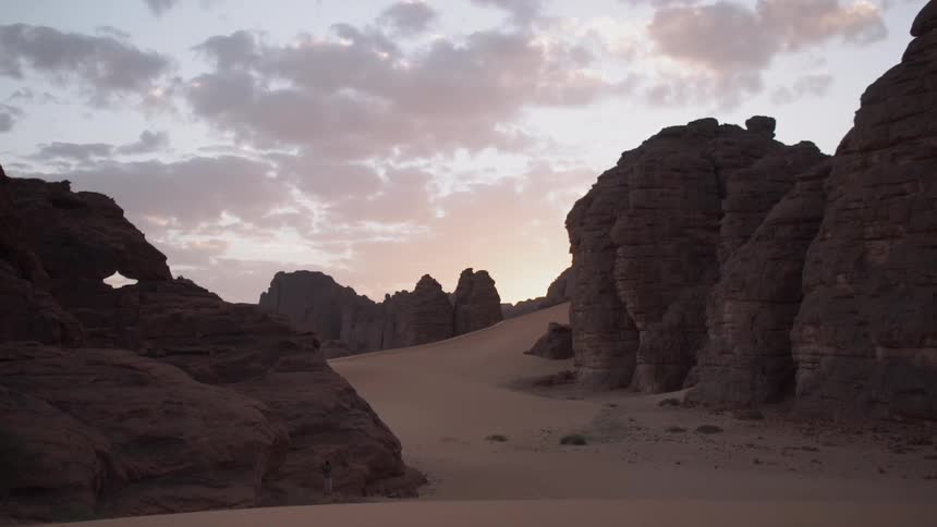 Rock formations and sand dunes in the desert at sunset