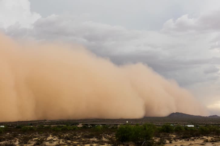 A dust storm approaches and engulfs a highway