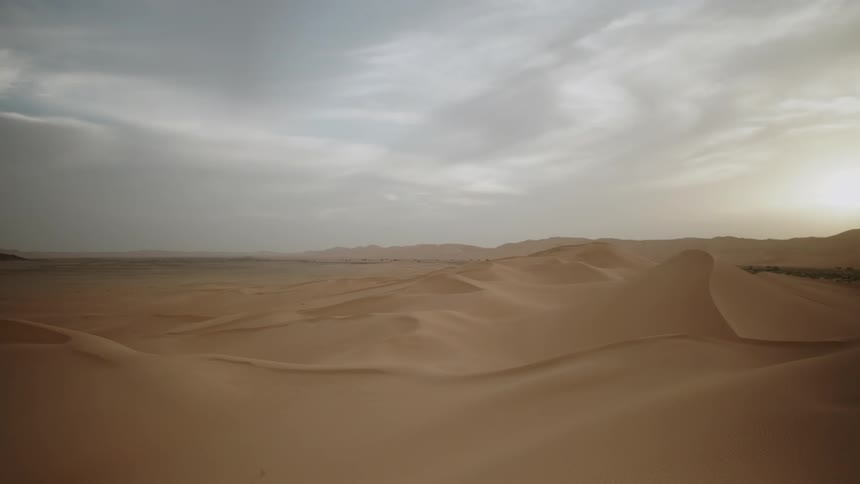 Clouds float above a sandy desert