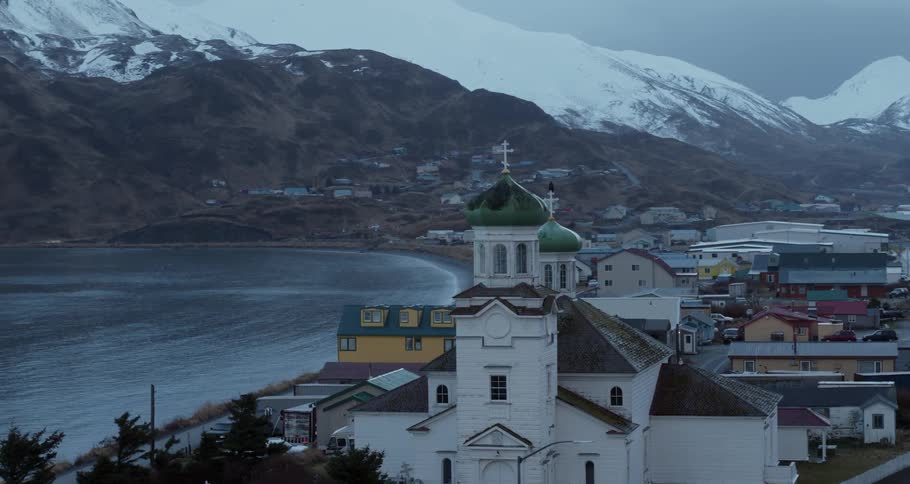 Houses in a village near a body of water and mountains