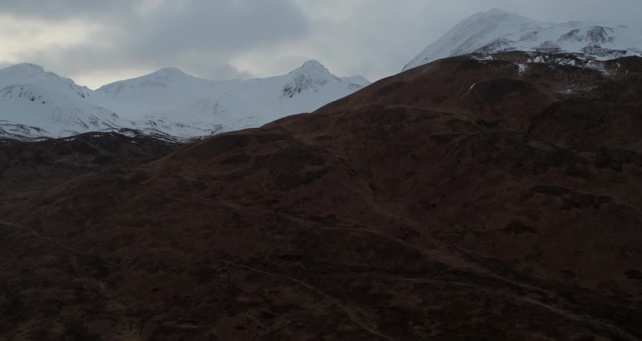 Clouds float over snowy mountain peaks