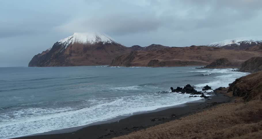 Ocean waves wash ashore on a cloudy day