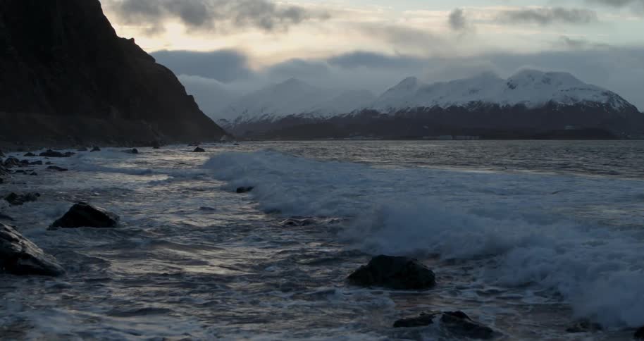 Water splashing onto rocks on shore