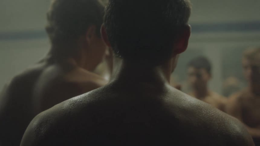 Men standing around a shower room while talking