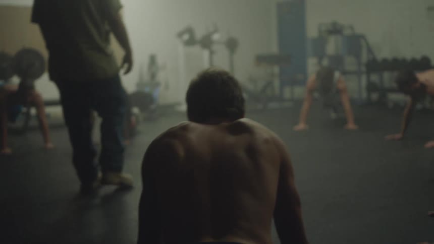 Group of young men doing push ups in a gym