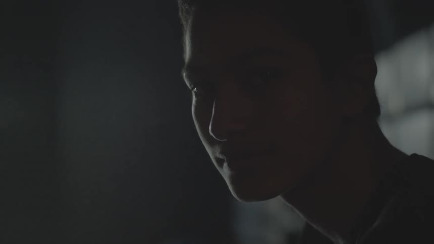 Man stands in dark area looking to his side