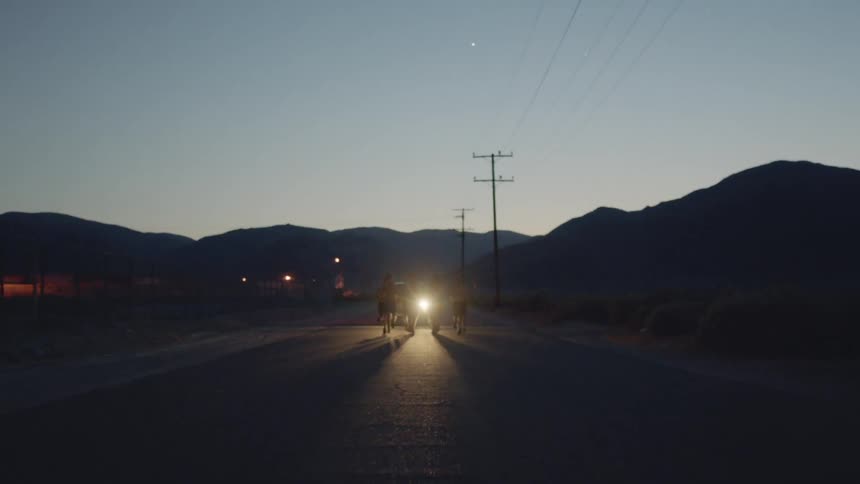 A group of young men run down a street before sunrise