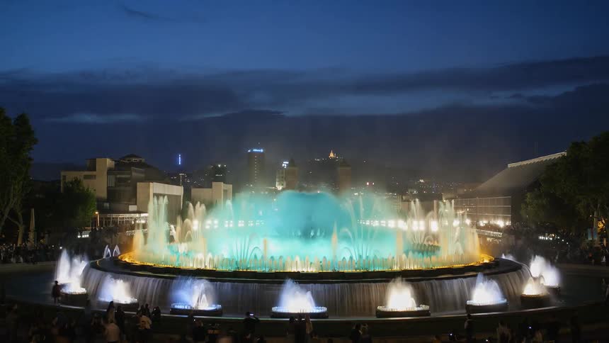 People walk around and watch the fountain water and color show