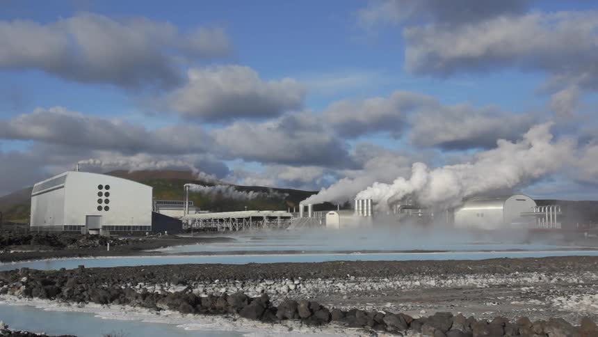 Smoke billowing from stacks in an industrial area on a cloudy day
