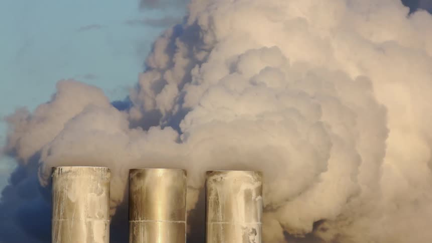 Smoke billows from factory smokestacks