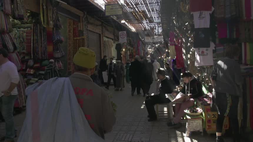 People walk and sit in a market place
