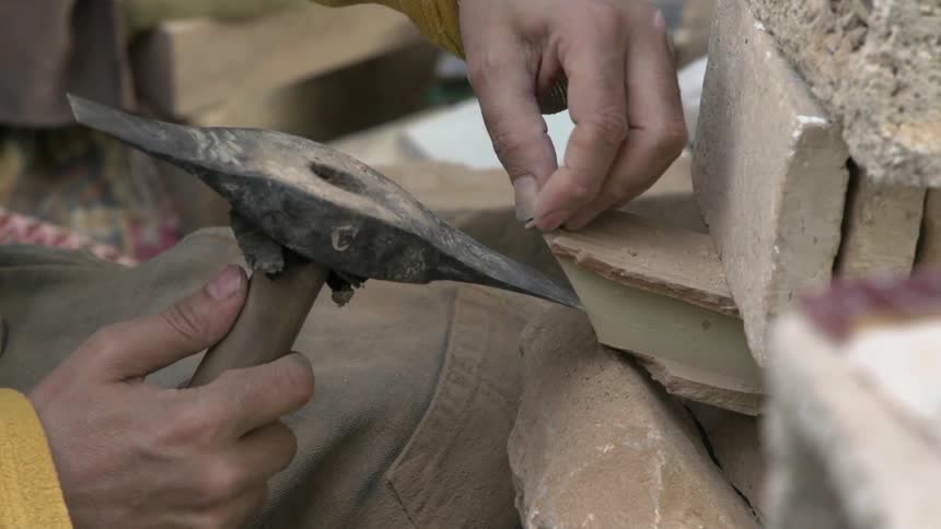 A man tacks carefully with a pick axe