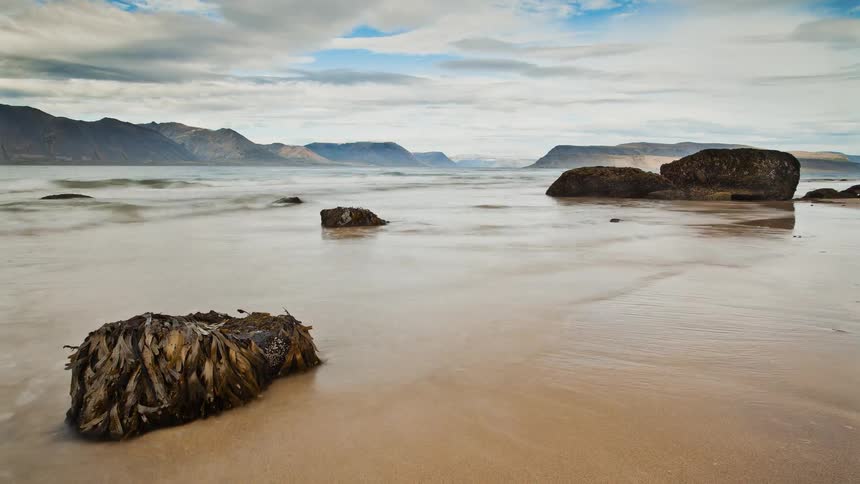 Time lapse of the tide coming in and going out on the beach