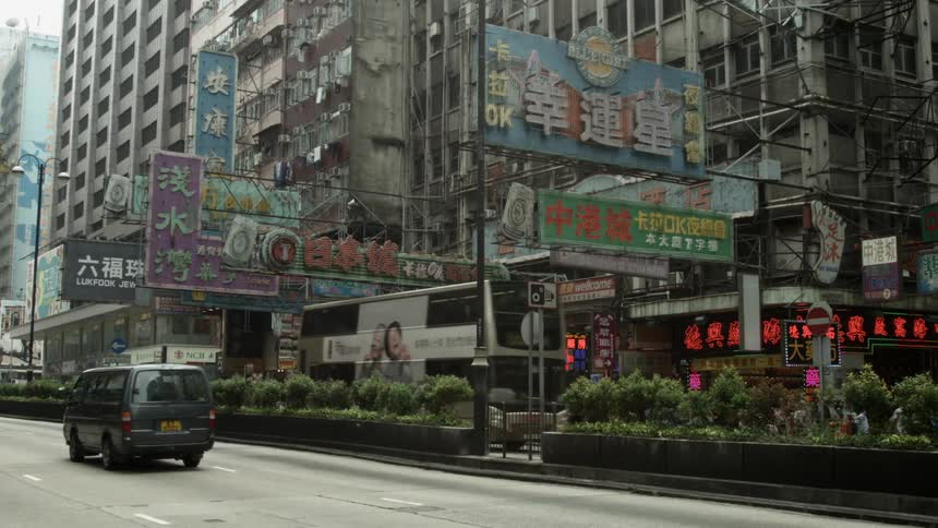 Cars and buses drive on a city street