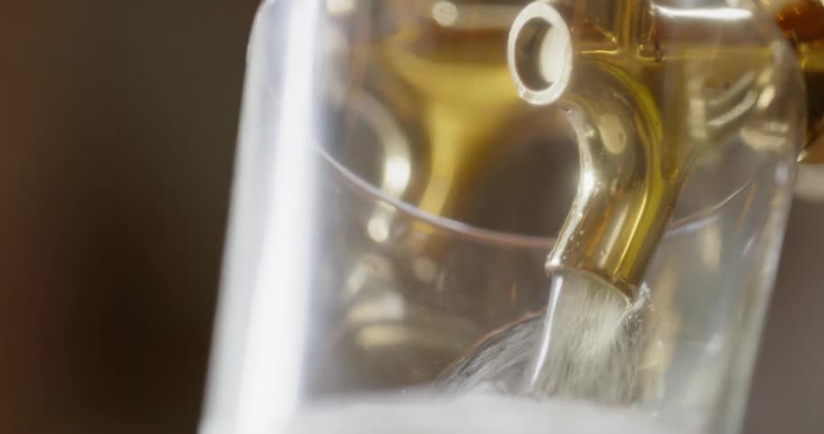 A glass is filled with a beer from the tap