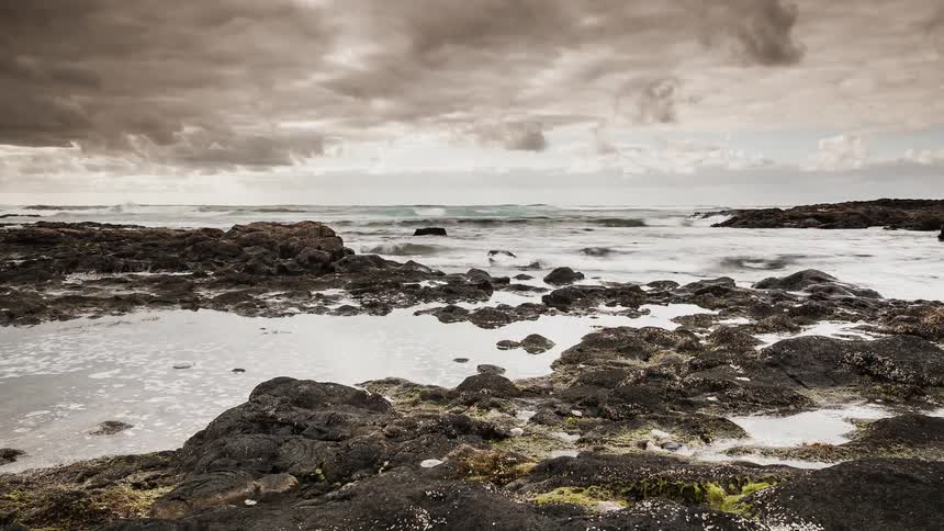 Ocean waves wash ashore a rocky beach