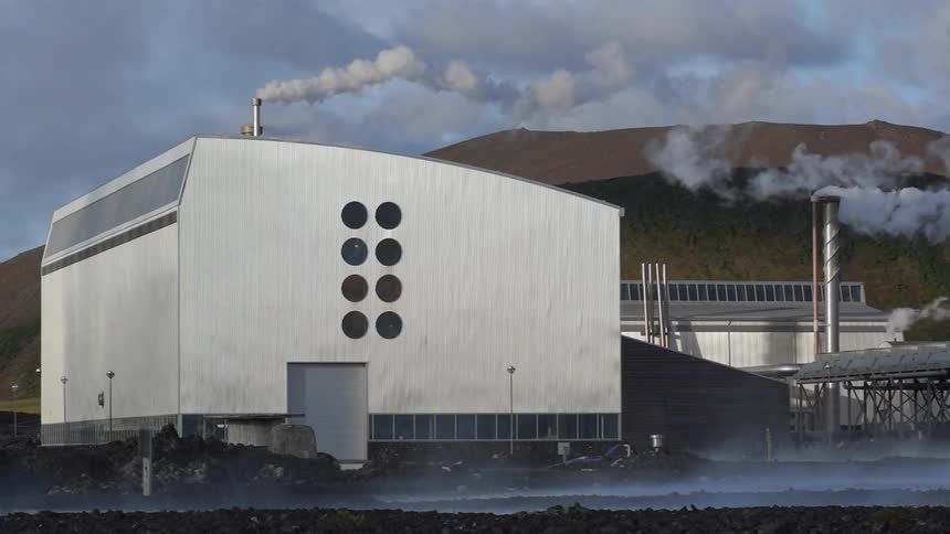 Steam is flowing from stacks in an industrial plant during the day