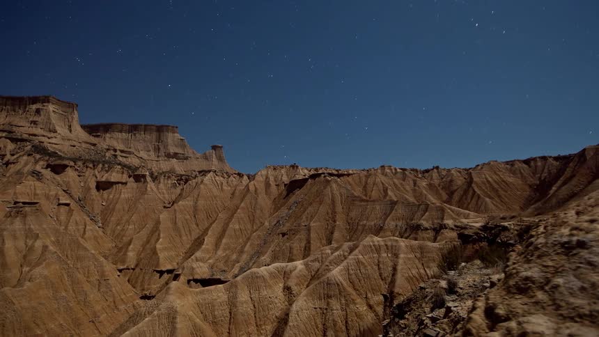 Stars swirl above canyons in the wilderness